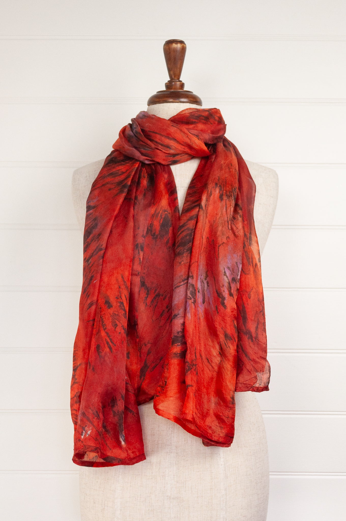 Tie dye silk scarf in shades of orange, magenta and bronze.