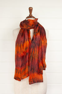 Tie dye silk scarf in shades of burnt orange, deep red and bronze.