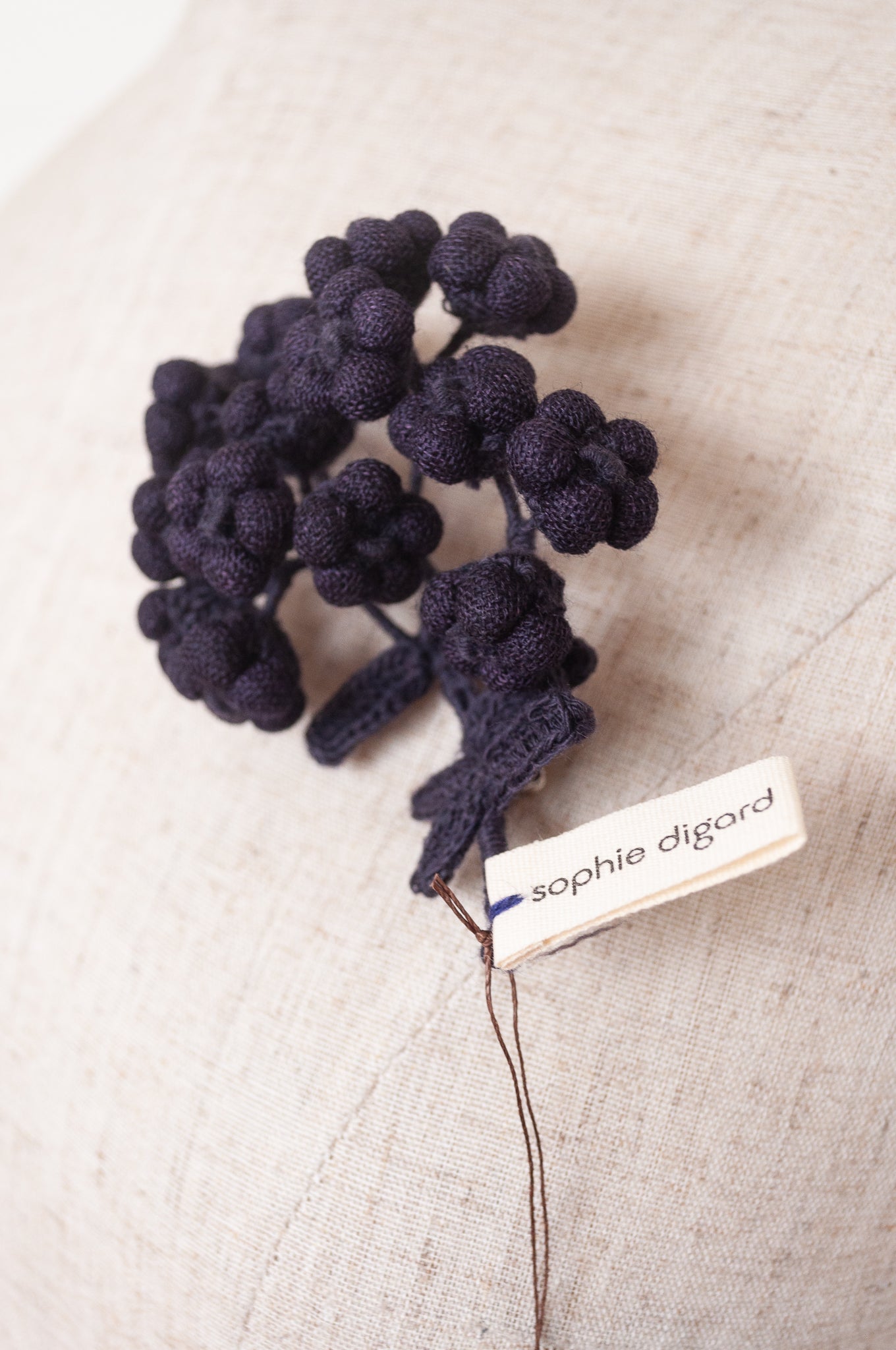 Classic Sophie Digard wool embroidered flower brooch Alpine in dark aubergine.