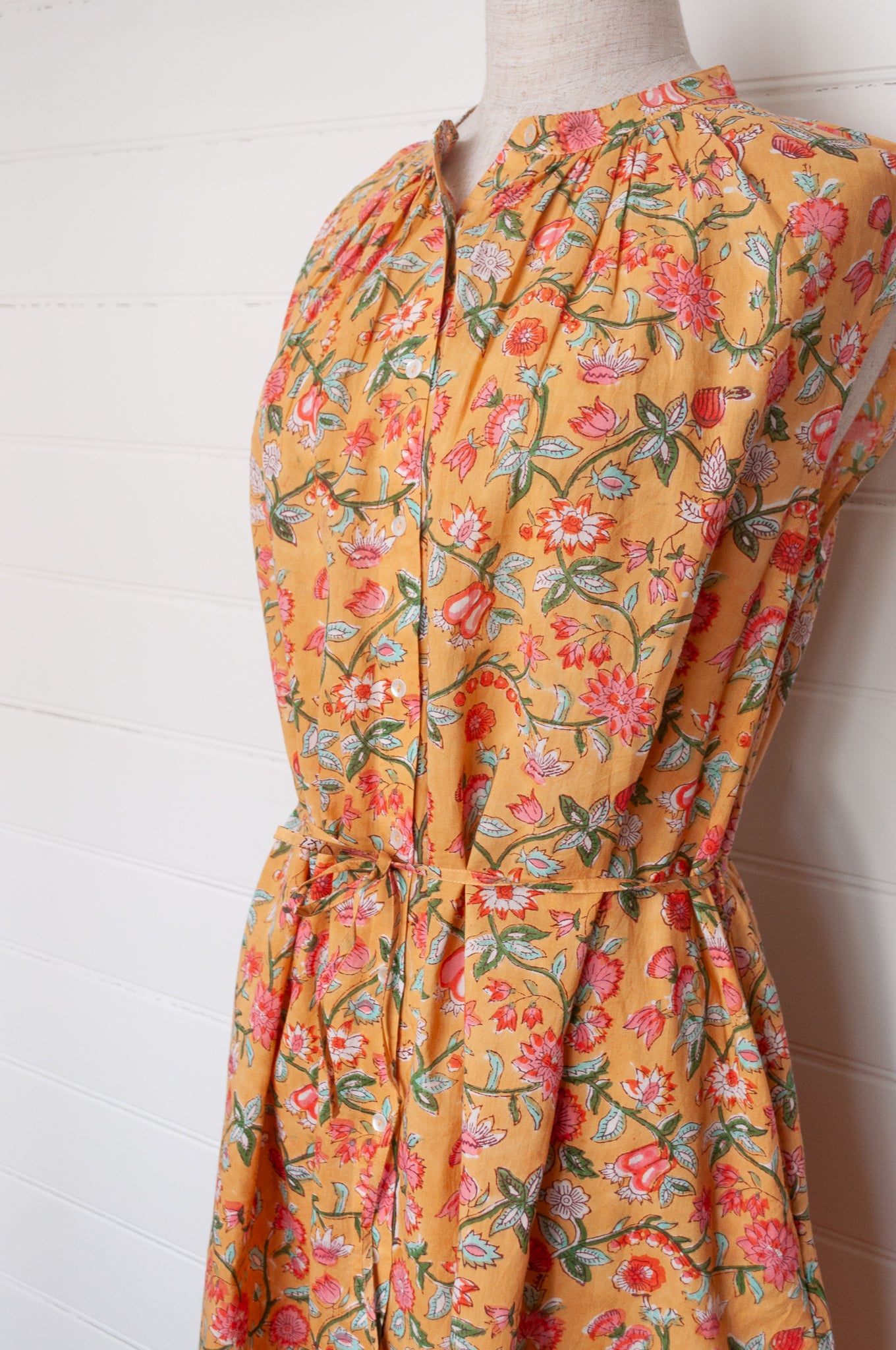 Juniper Hearth Zoe blockprint floral sleeveless cotton dress, buttonup with waist tie, in mustard yellow.