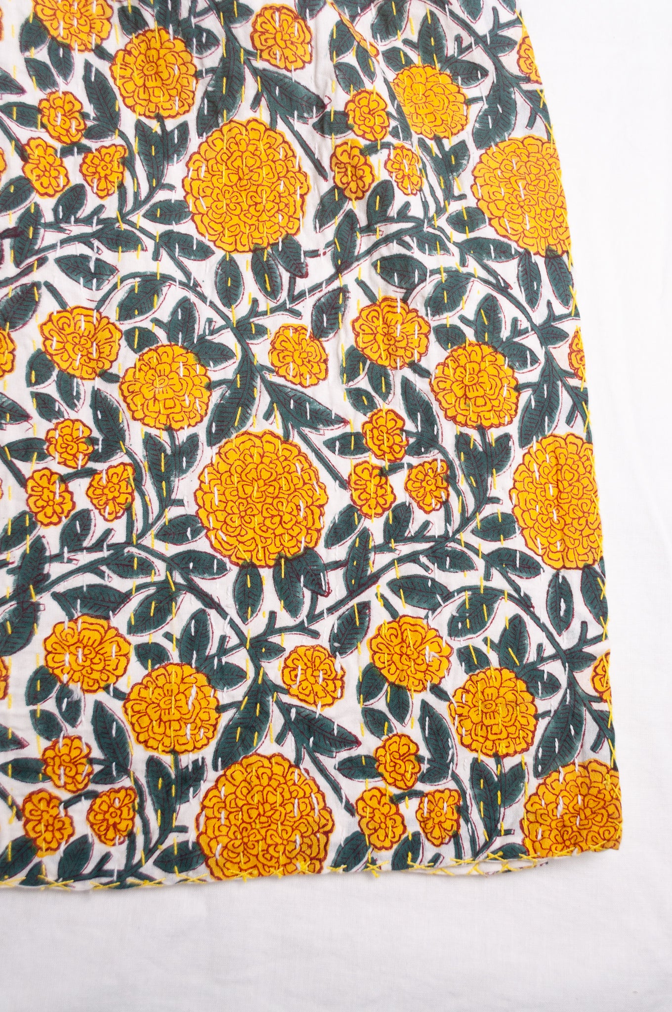 Hand stitched block print pure cotton kantha quilt marigold yellow and dark green floral on white.