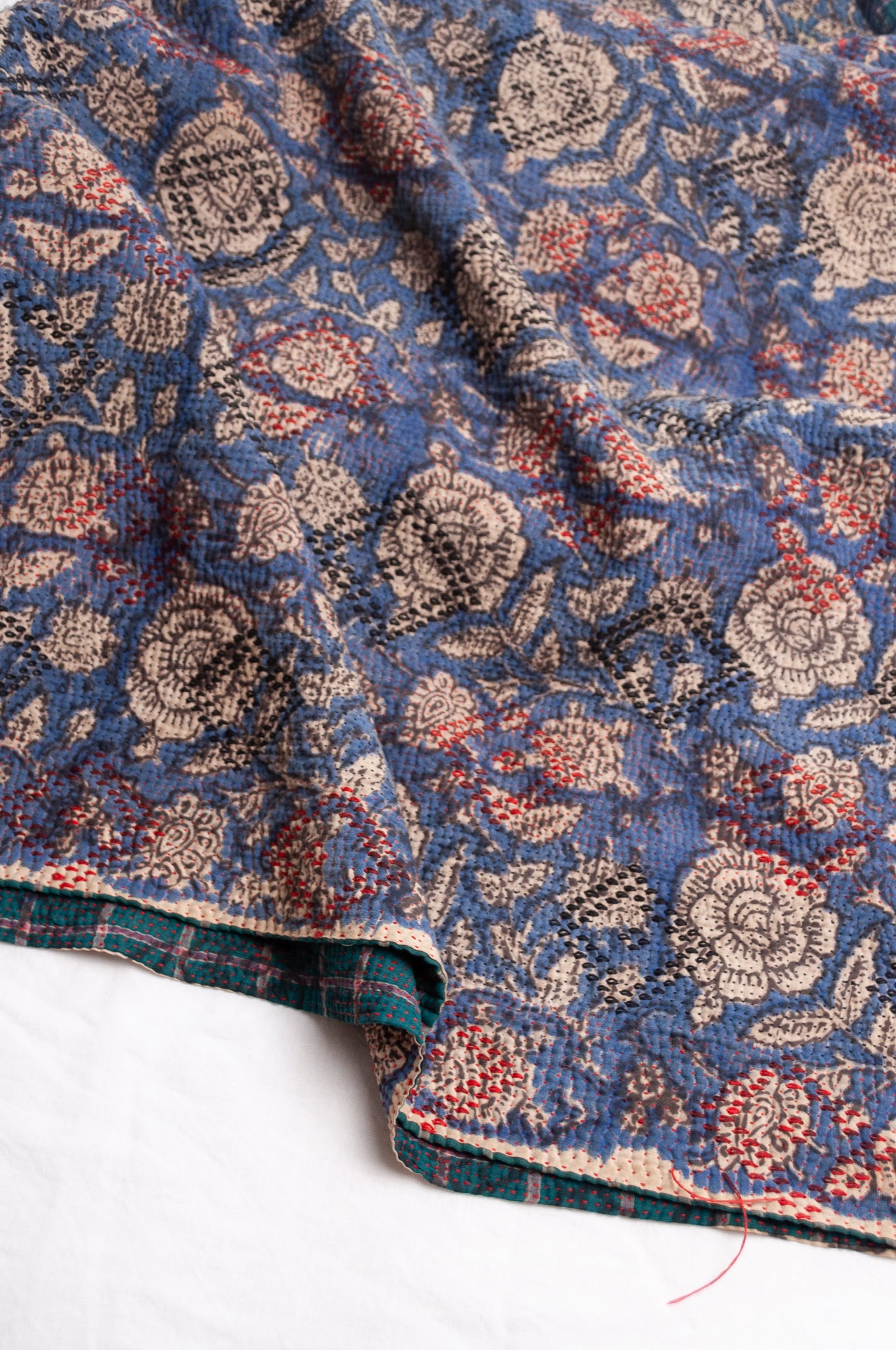 Bagru over print vintage blockprint kantha quilt, floral on denim blue with red embroidery and green plaid reverse.