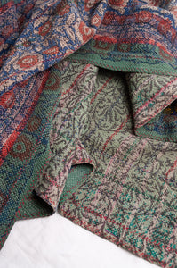 Bagru overdye blockprint vintage kantha quilt in red, ecru and denim blue with green borders.