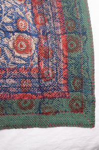 Bagru overdye blockprint vintage kantha quilt in red, ecru and denim blue with green borders.