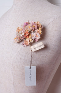 Sophie Digard crocheted flower brooch in warm neutral tones.