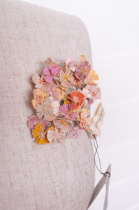 Sophie Digard crocheted flower brooch in warm neutral tones.