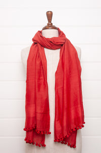 Silk and cotton scarf with pom poms in tomato red.