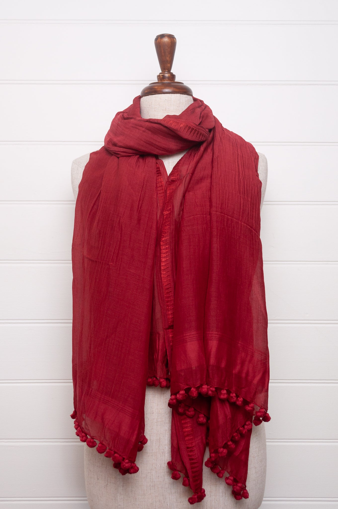 Silk and cotton scarf with pom poms in crimson red.