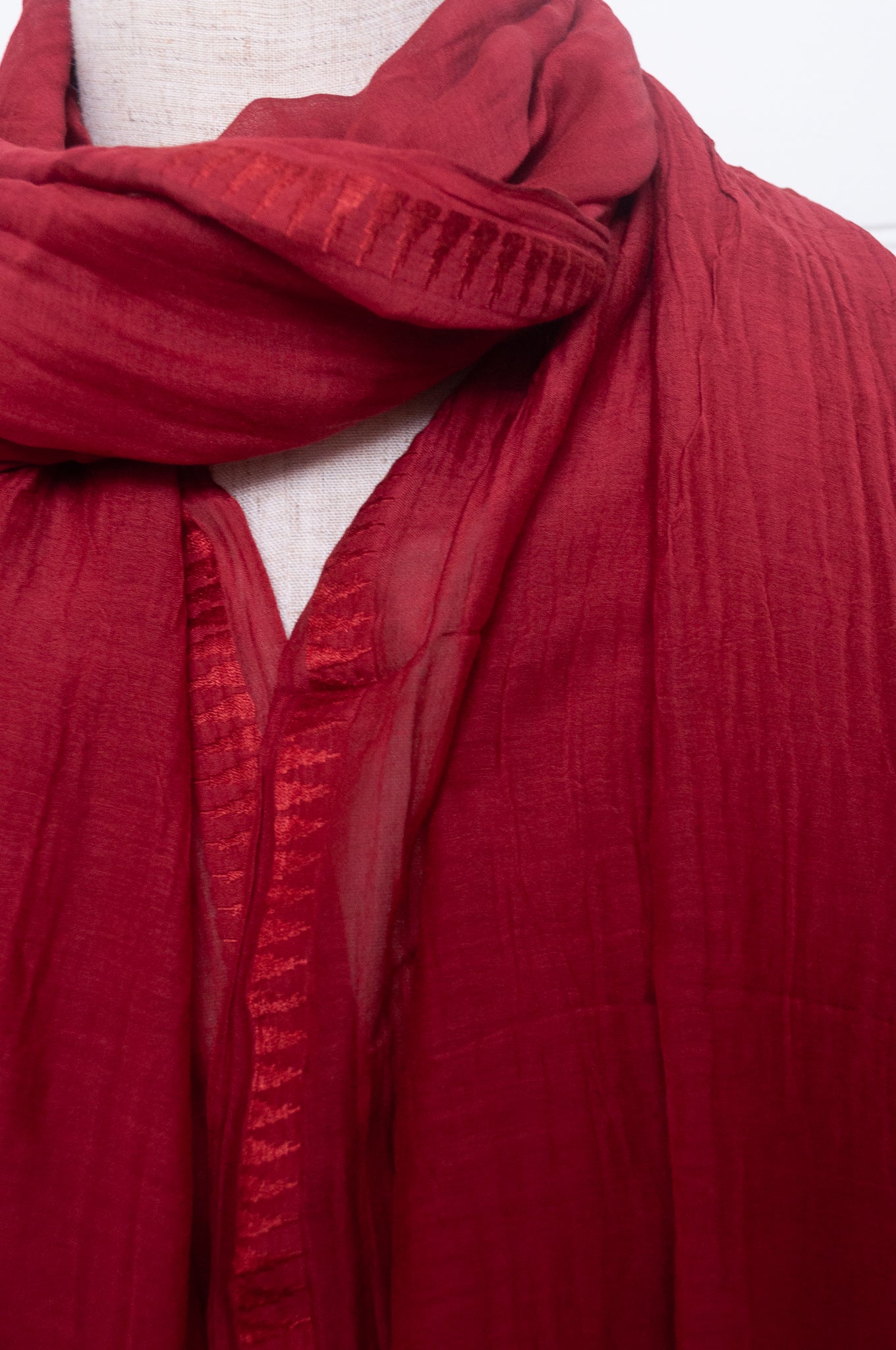 Silk and cotton scarf with pom poms in crimson red.
