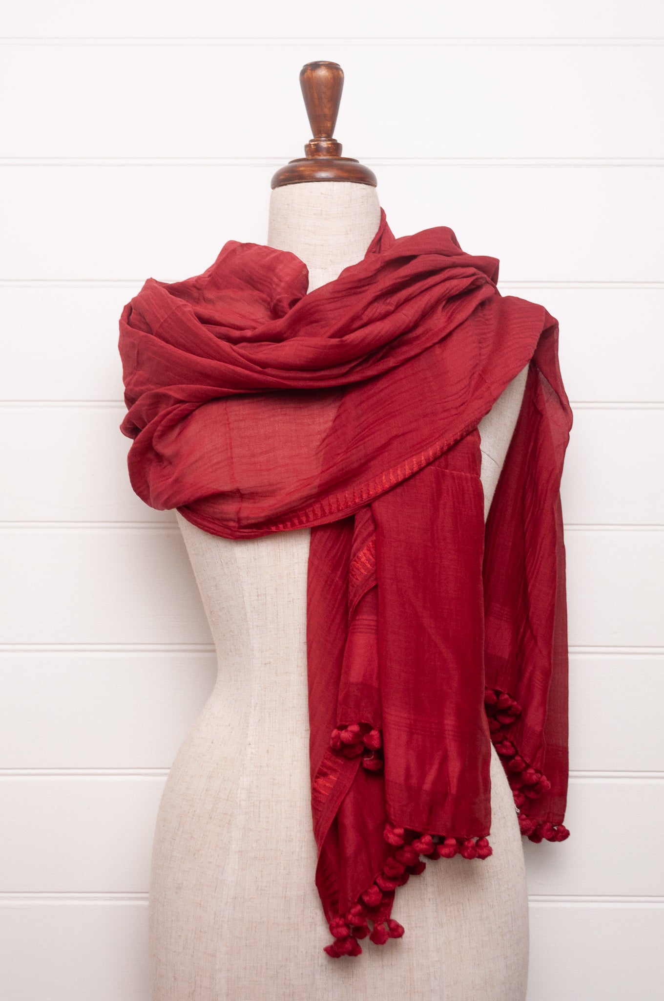 Silk and cotton scarf with pom poms in crimson red.