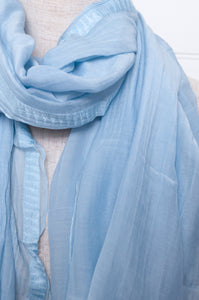 Silk and cotton scarf with pom poms in sky blue.