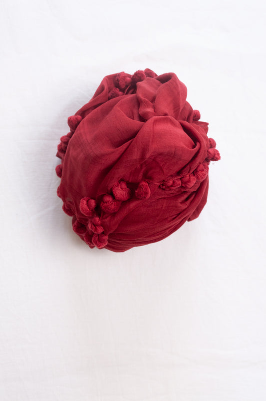 Silk and cotton scarf with pom poms in crimson red.