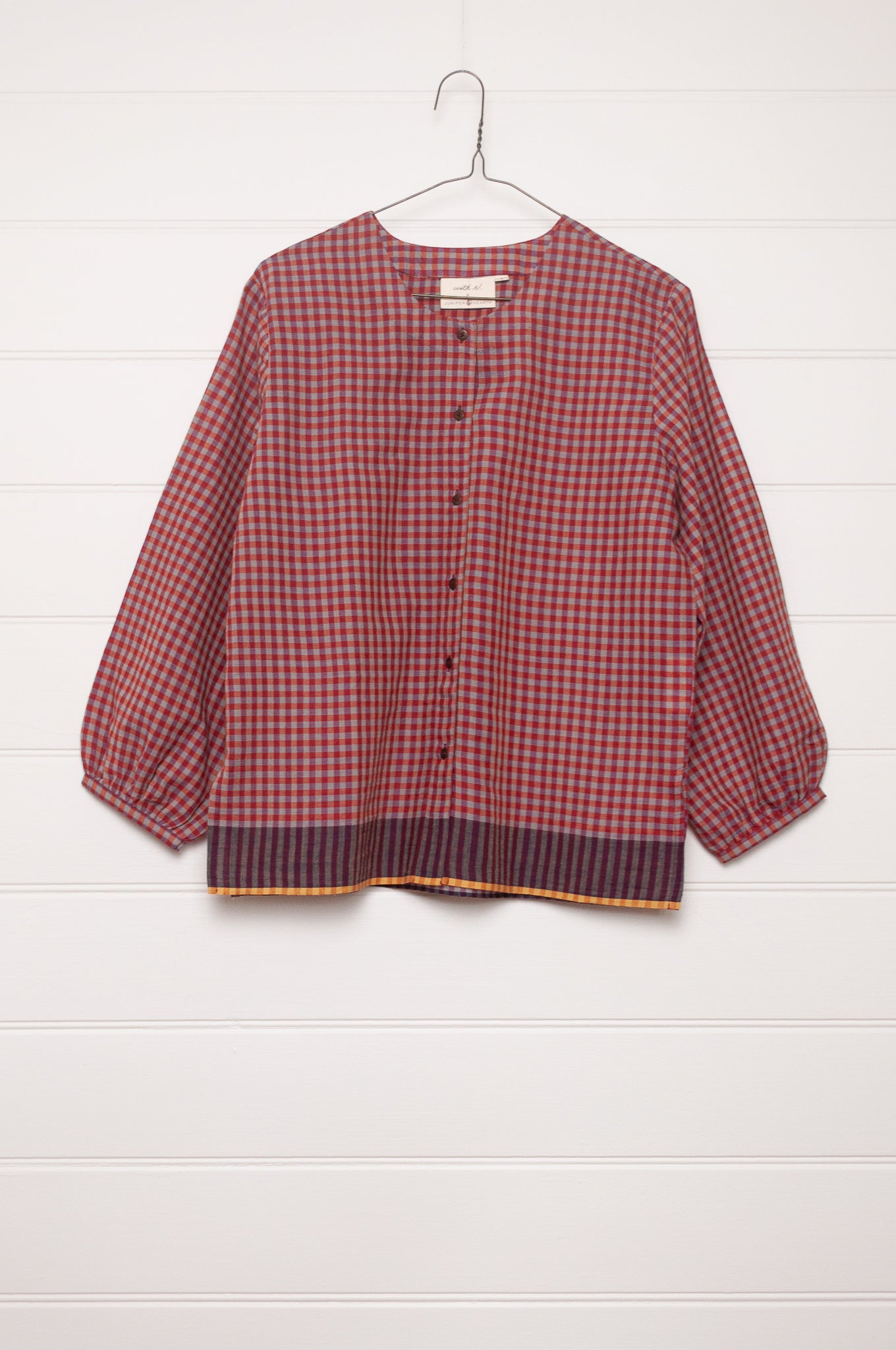 Handloom check cotton button up round neck blouse with long sleeves and selvedge hem detail.