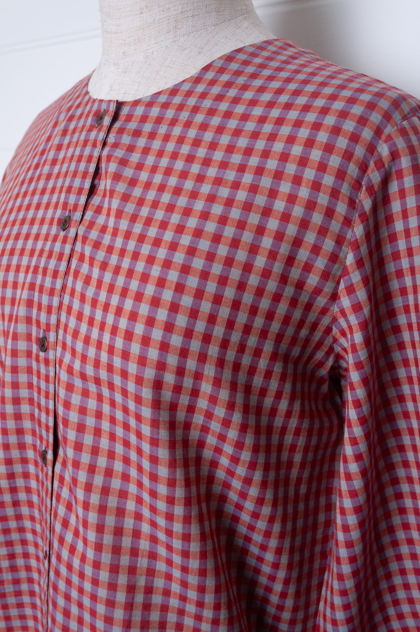Handloom check cotton button up round neck blouse with long sleeves and selvedge hem detail.