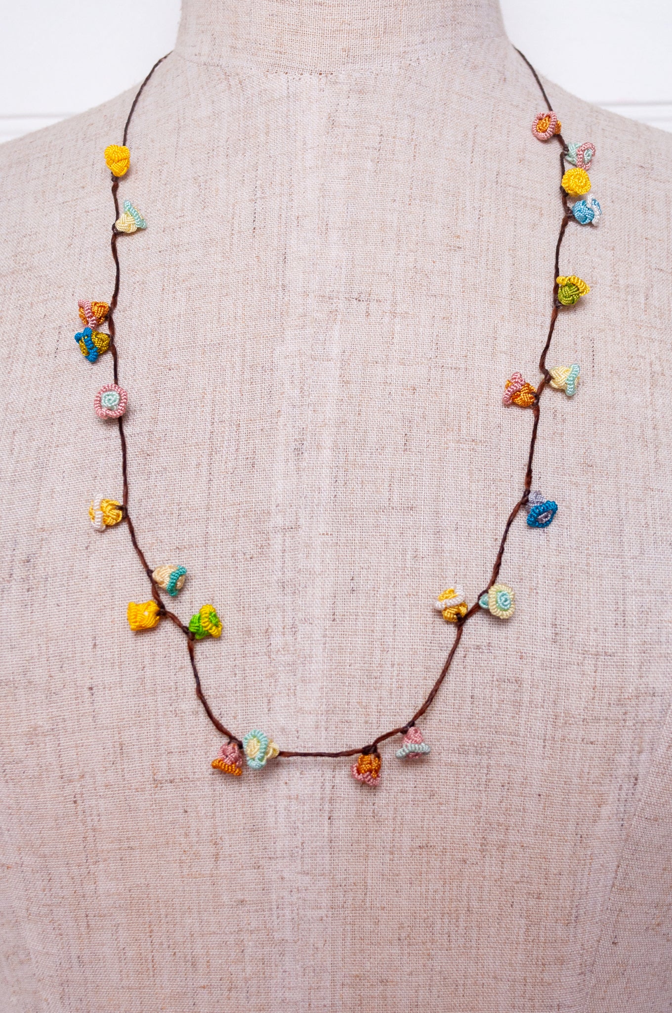 Handmade Moroccan button necklace in sky blue, soft yellow, rose pink and latte.
