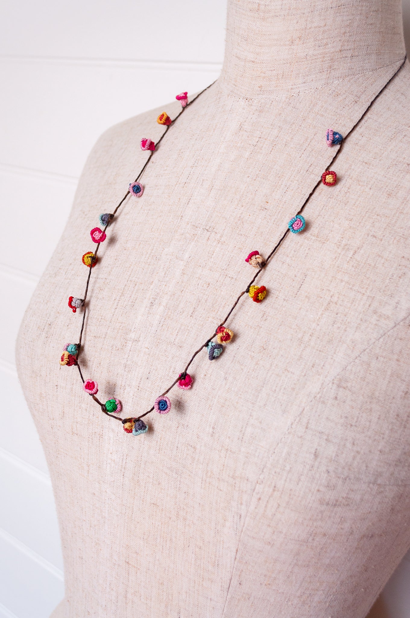 Handmade Moroccan button necklace in bright pastels blue, lemon yellow, rose pink.
