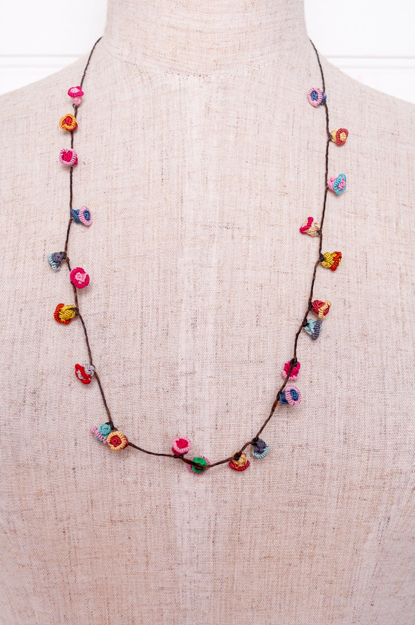 Handmade Moroccan button necklace in bright pastels blue, lemon yellow, rose pink.