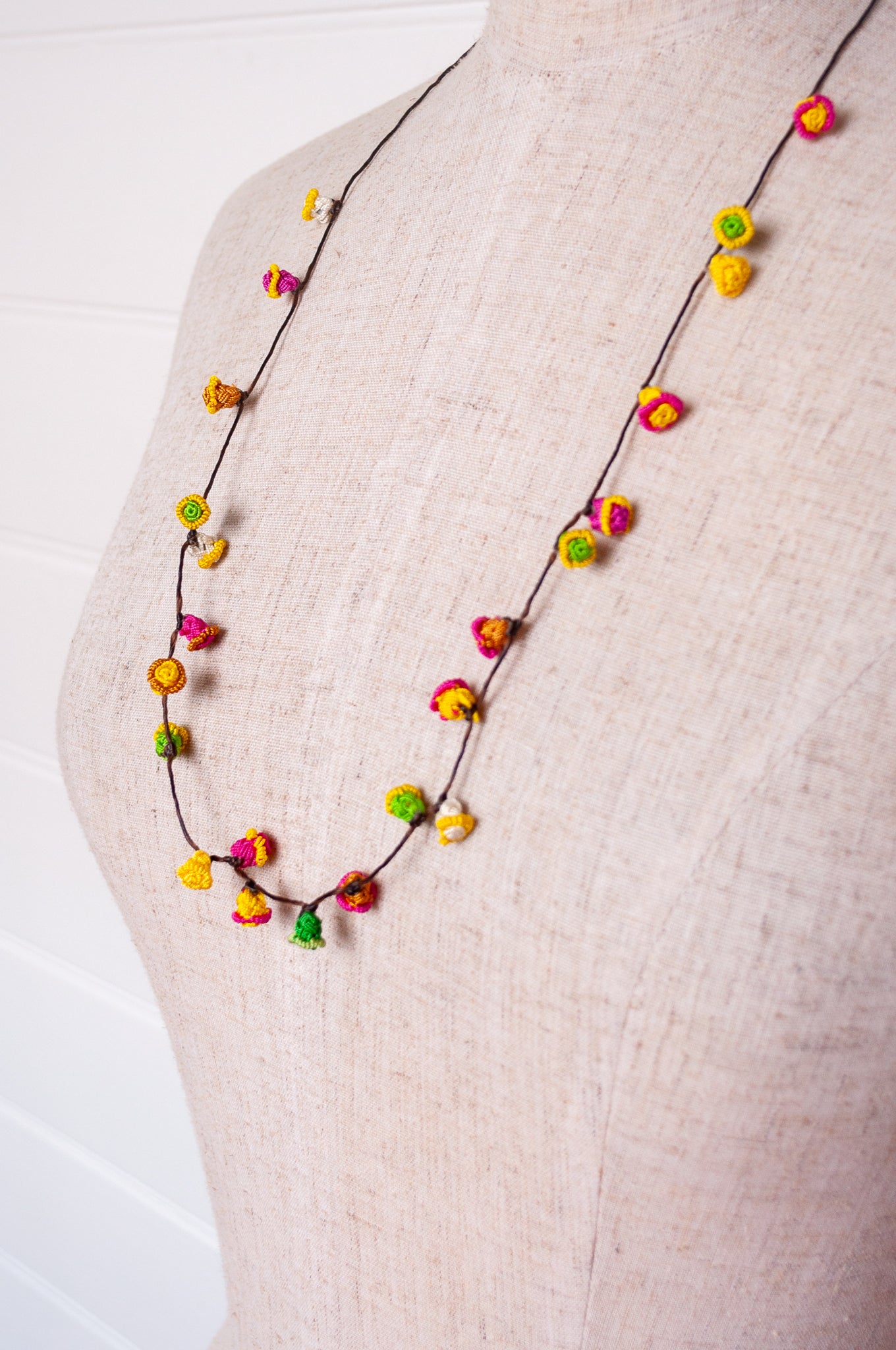 Handmade Moroccan button necklace in bright lemon yellow, rose pink and leaf green.