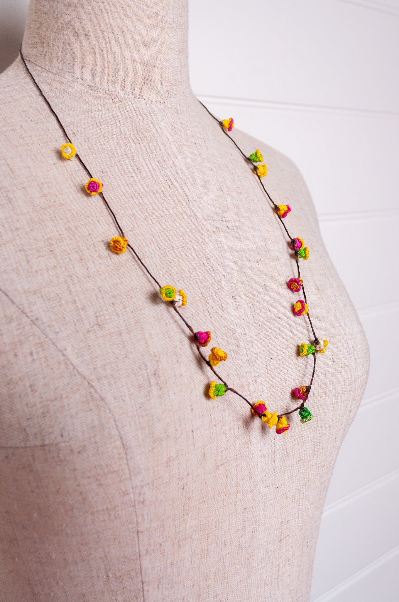 Handmade Moroccan button necklace in bright lemon yellow, rose pink and leaf green.