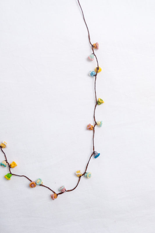 Handmade Moroccan button necklace in sky blue, soft yellow, rose pink and latte.