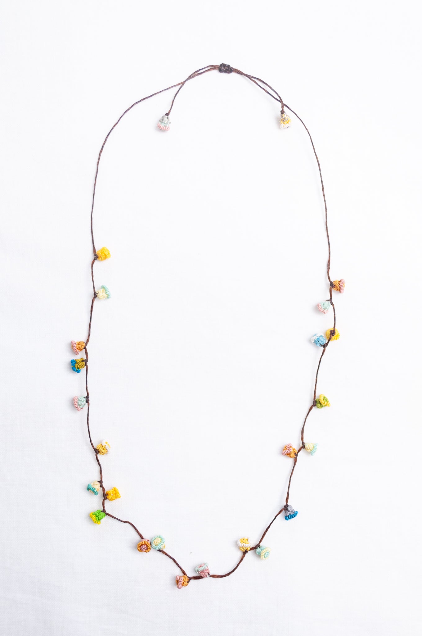 Handmade Moroccan button necklace in sky blue, soft yellow, rose pink and latte.