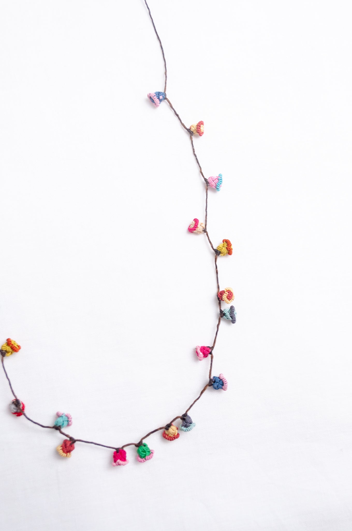Handmade Moroccan button necklace in bright pastels blue, lemon yellow, rose pink.