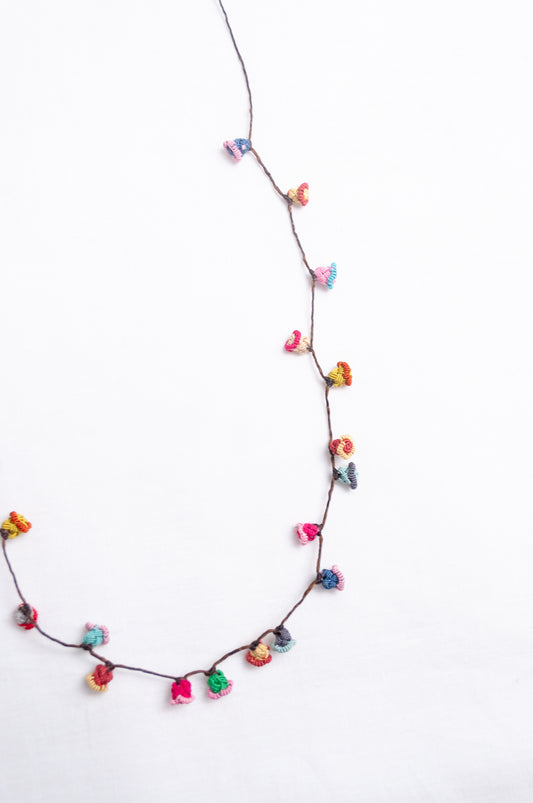 Handmade Moroccan button necklace in bright pastels blue, lemon yellow, rose pink.