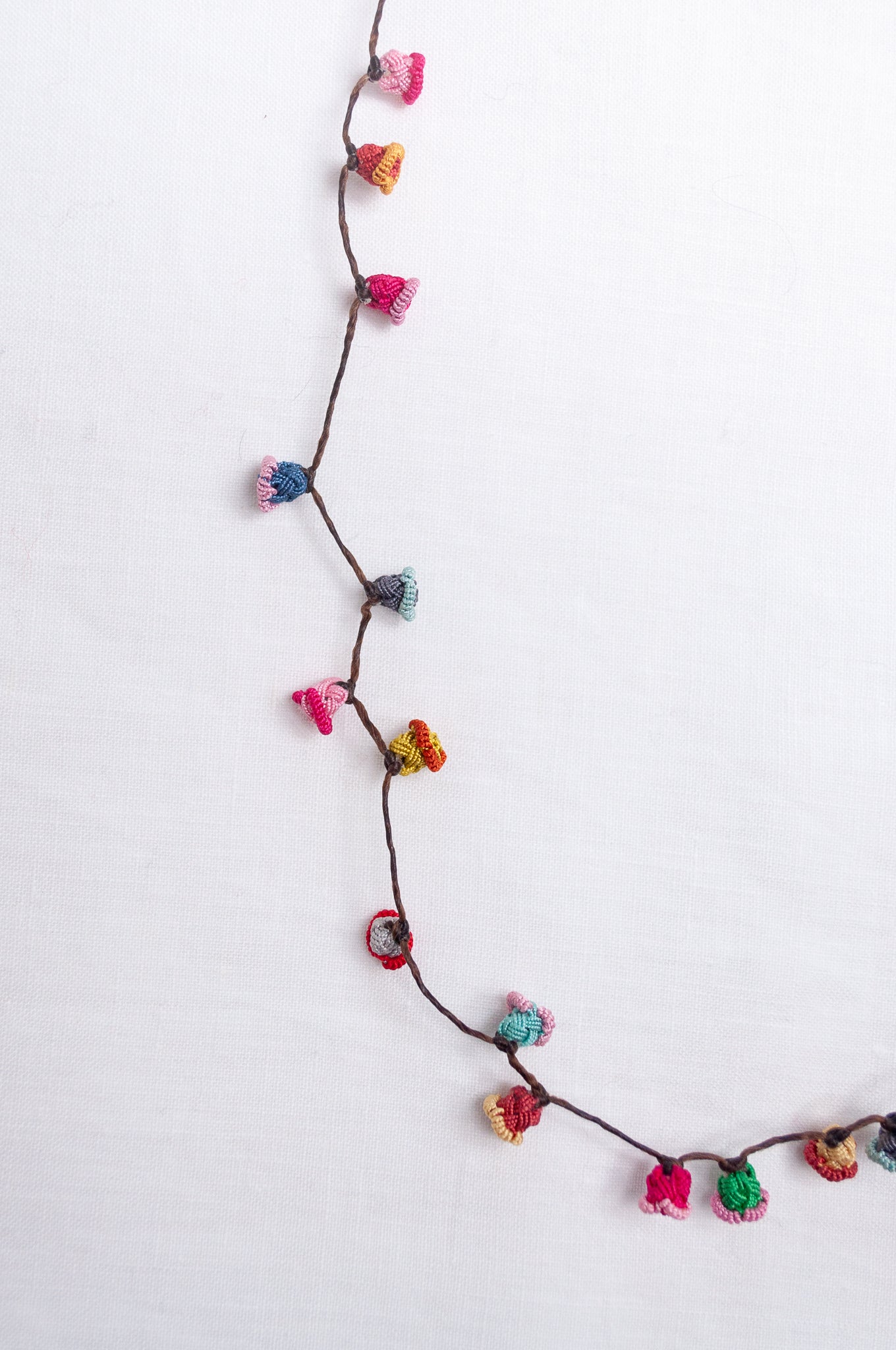 Handmade Moroccan button necklace in bright pastels blue, lemon yellow, rose pink.