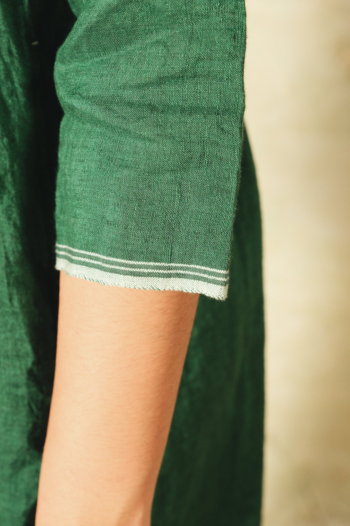 Dve emerald green linen Raka dress pintucked bodice, showing sleeve selvedge details.