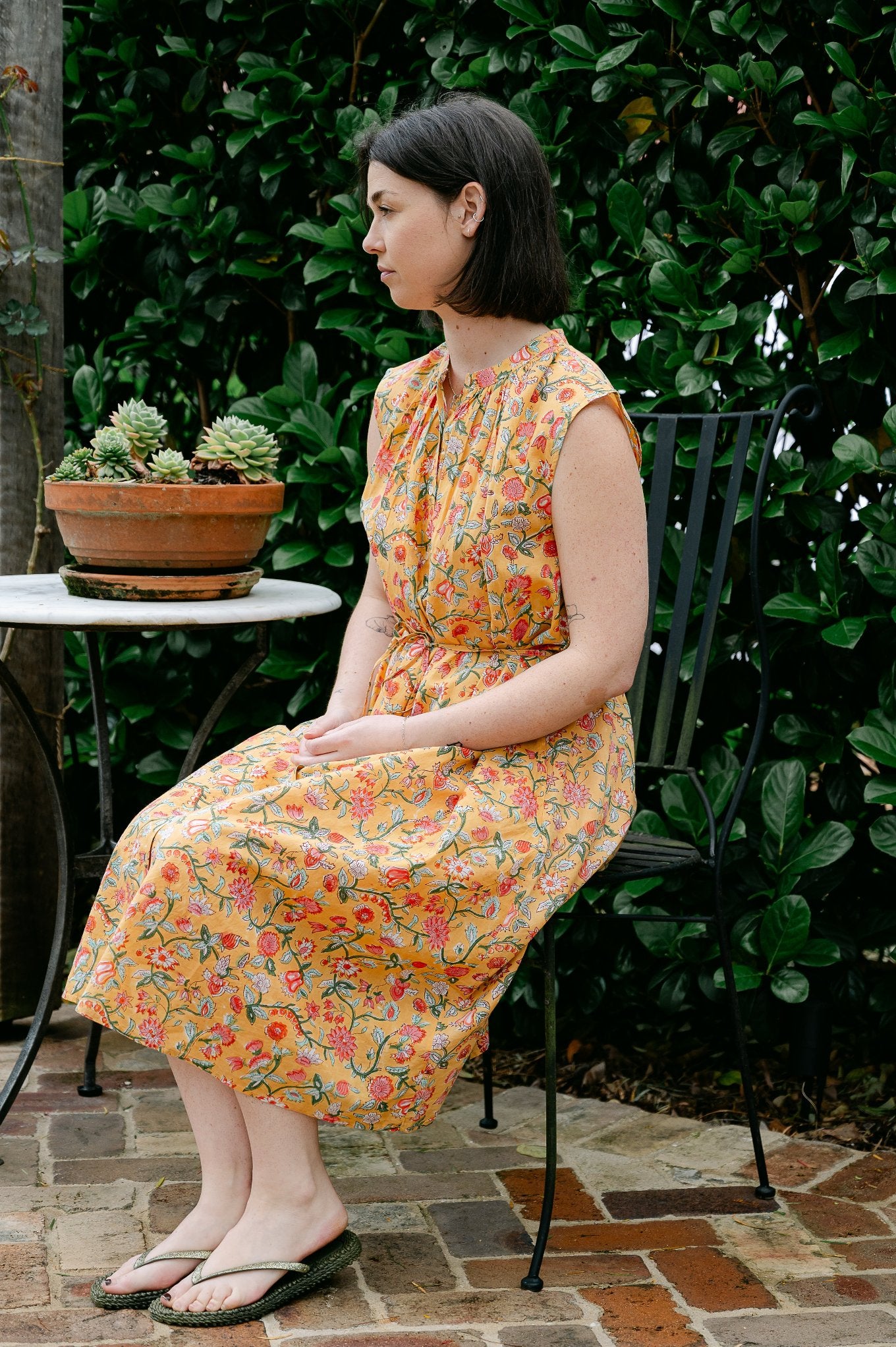 Juniper Hearth Zoe blockprint floral sleeveless cotton dress, buttonup with waist tie, in mustard yellow.