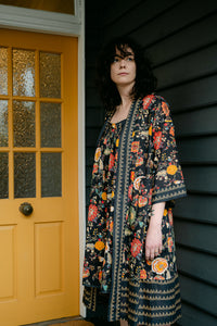 Juniper Hearth cotton voile nightdress in a vibrant all over tropical floral in coral, ecru and olive green on a black background, with matching kimono gown.