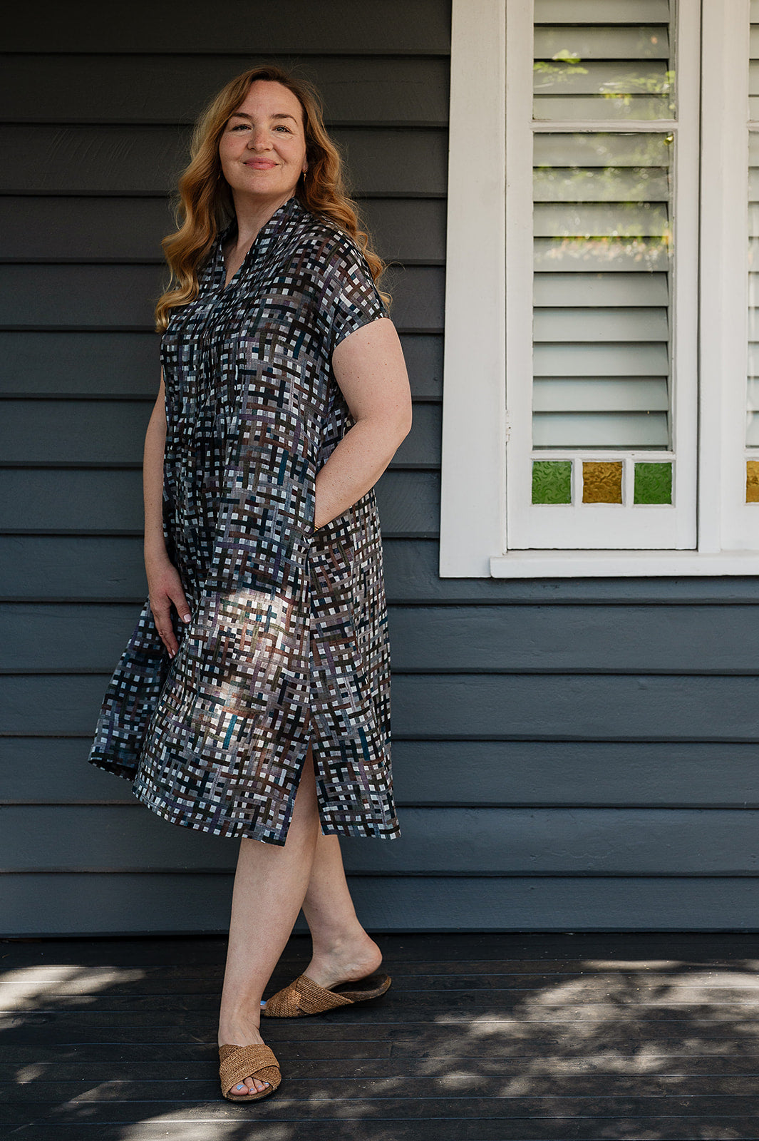 Neeru Kumar fine cotton pintucked  cap sleeved dress in charcoal and brown checks with teal highlights.