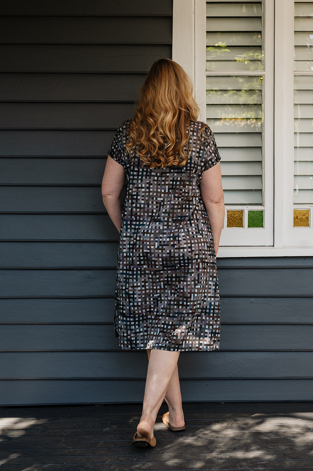 Neeru Kumar fine cotton pintucked  cap sleeved dress in charcoal and brown checks with teal highlights.