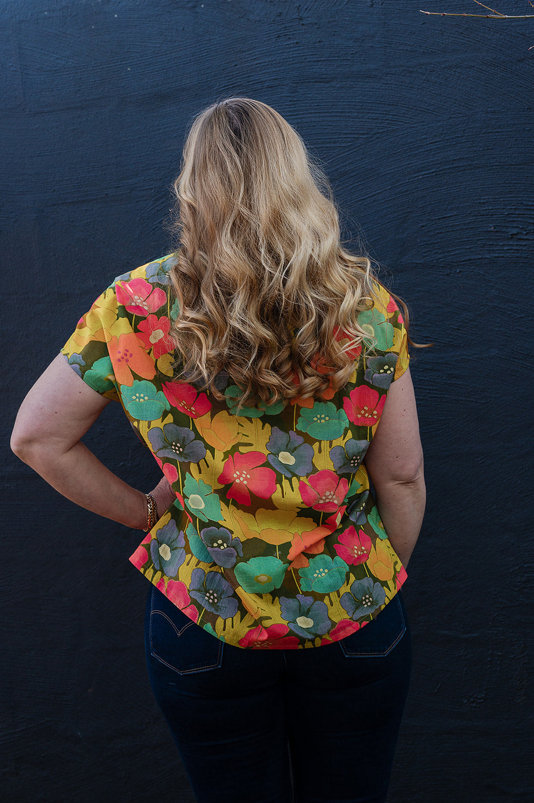 Neeru Kumar round neck cap sleeve top with a colorful floral pattern.