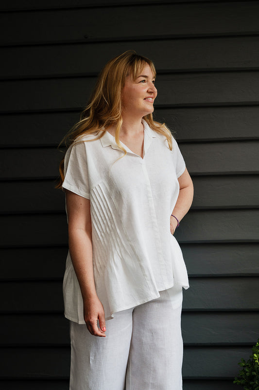 Manan Bonnie loose-fitting button up top with side pleat detailing in white linen.