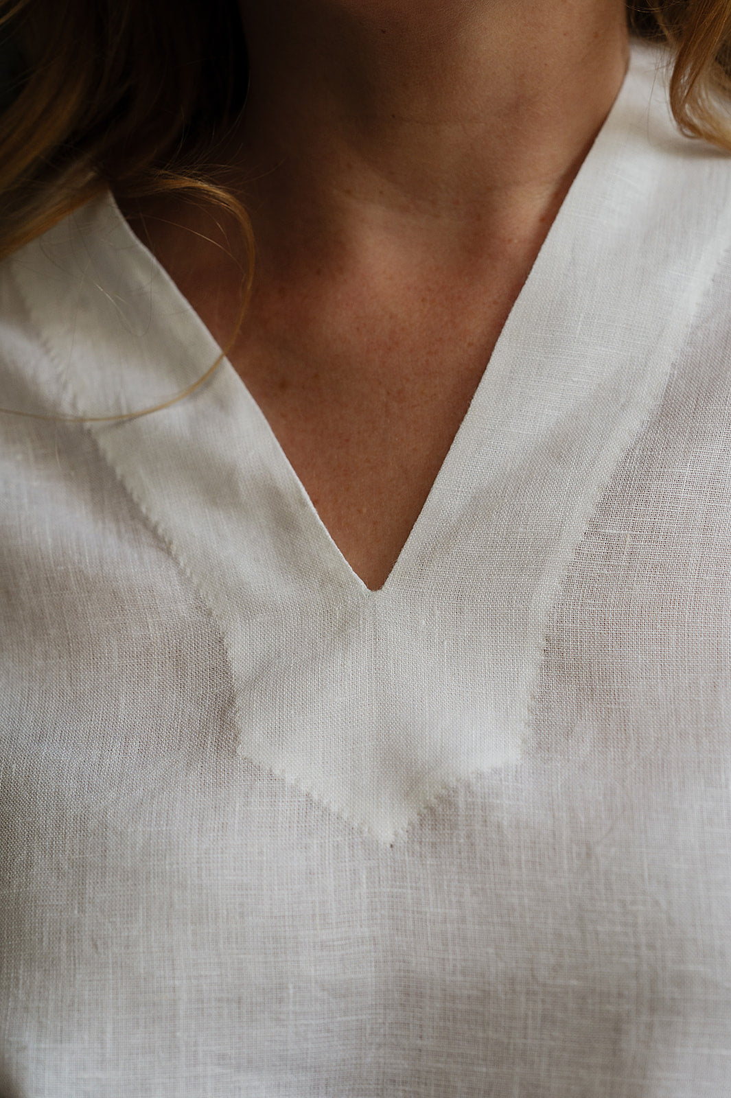 Manan Hoshi top with V-neck and elasticated short sleeves in white linen.
