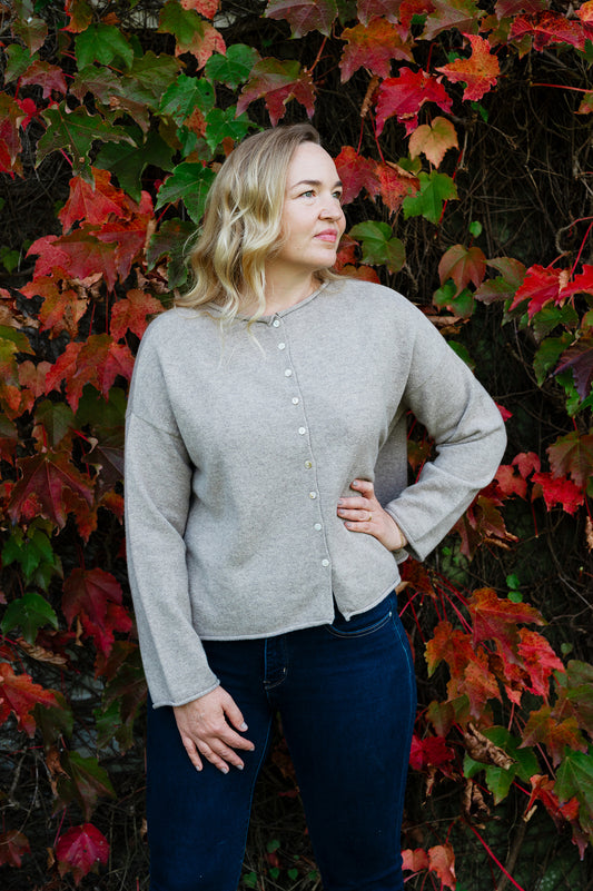 Juniper Hearth ash grey marle reversible one size cashmere cardigan, roll neck edges to neck, sleeves and hem, shell buttons, can be worn as a cardigan or reversed as a sweater.