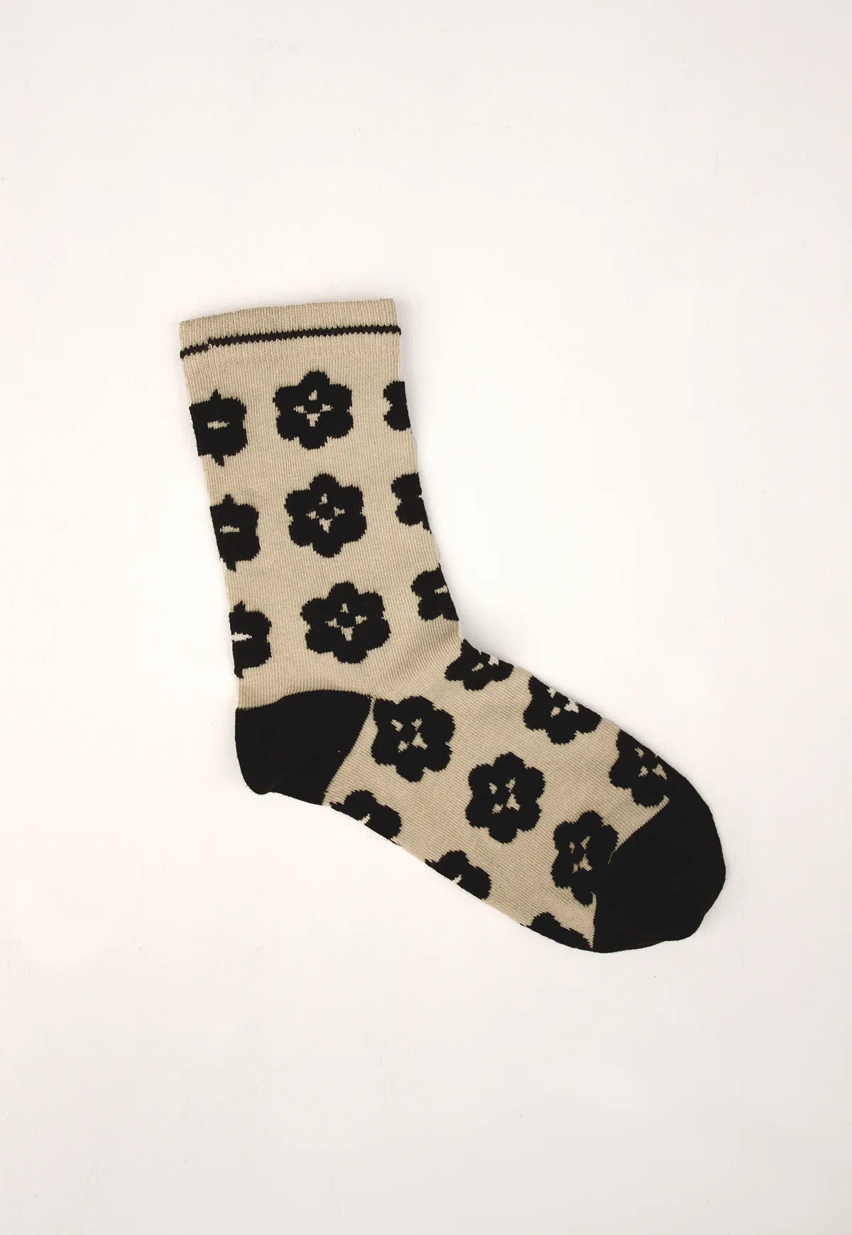 Nancybird Orakawa beige sock with black floral pattern on a white background.