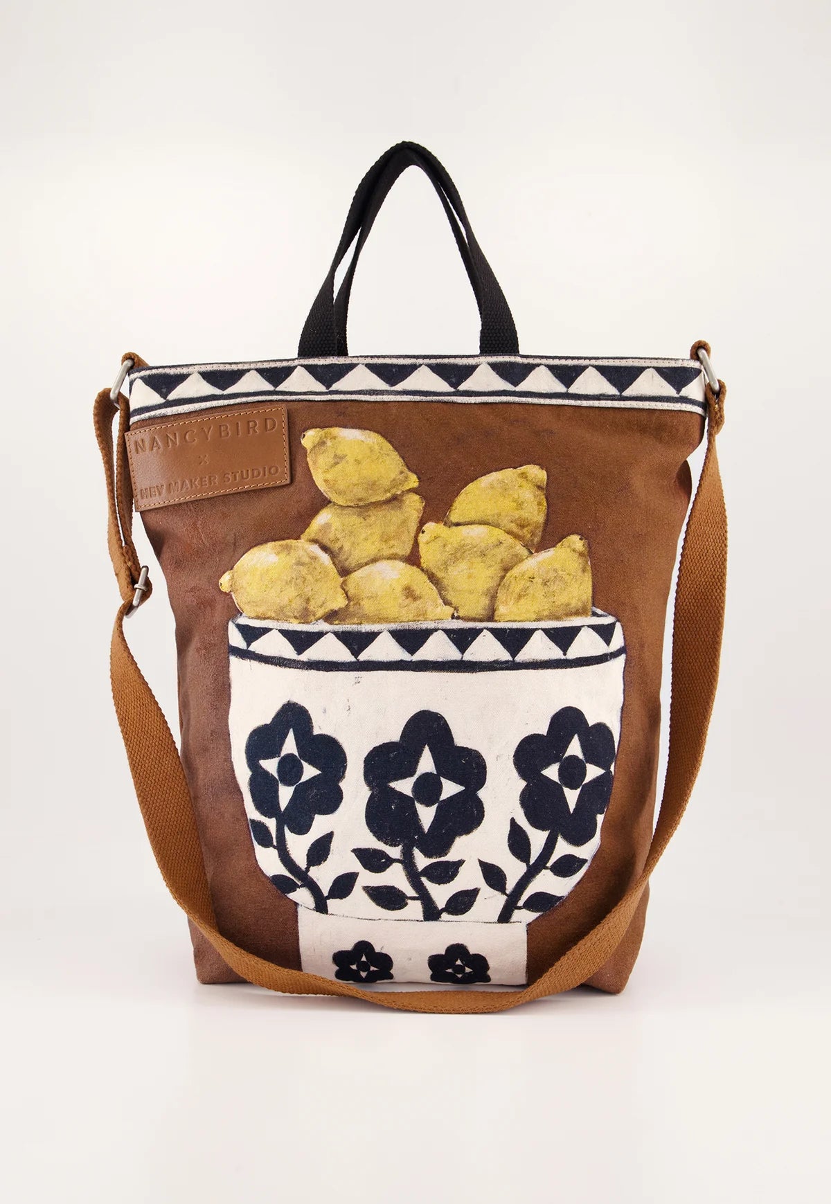 Nancybird brown shoulder bag featuring a front pocket printed with yellow lemons and a white floral pattern, set against a clean white background.