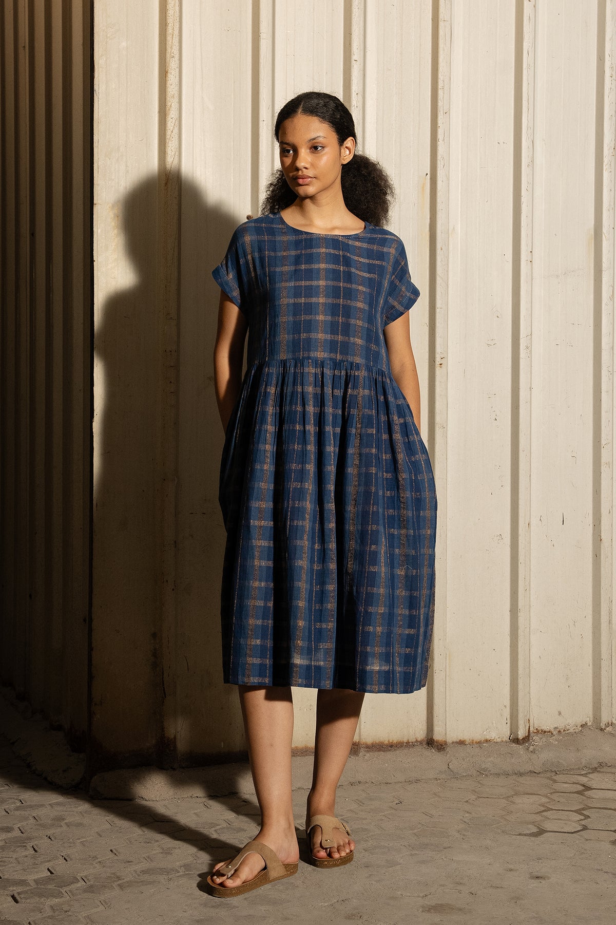 DVE Rayna dress in handloom indigo check cotton with subtle lurex stripe, cap sleeves and gathered skirt with side pockets.