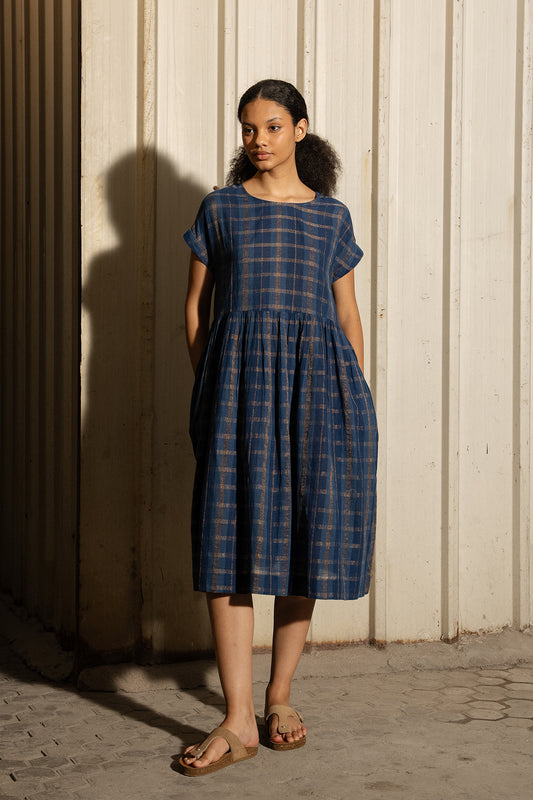 DVE Rayna dress in handloom indigo check cotton with subtle lurex stripe, cap sleeves and gathered skirt with side pockets.