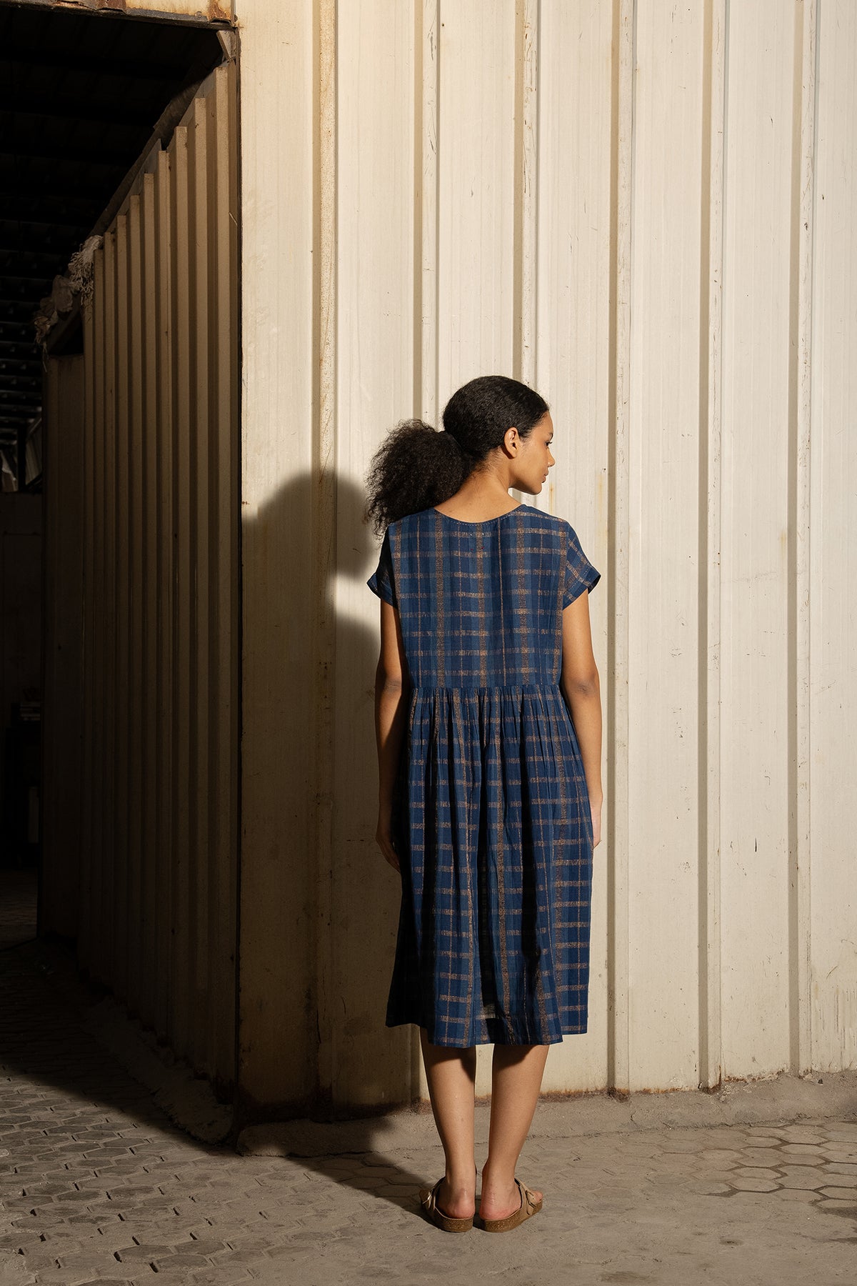 DVE Rayna dress in handloom indigo check cotton with subtle lurex stripe, cap sleeves and gathered skirt with side pockets.