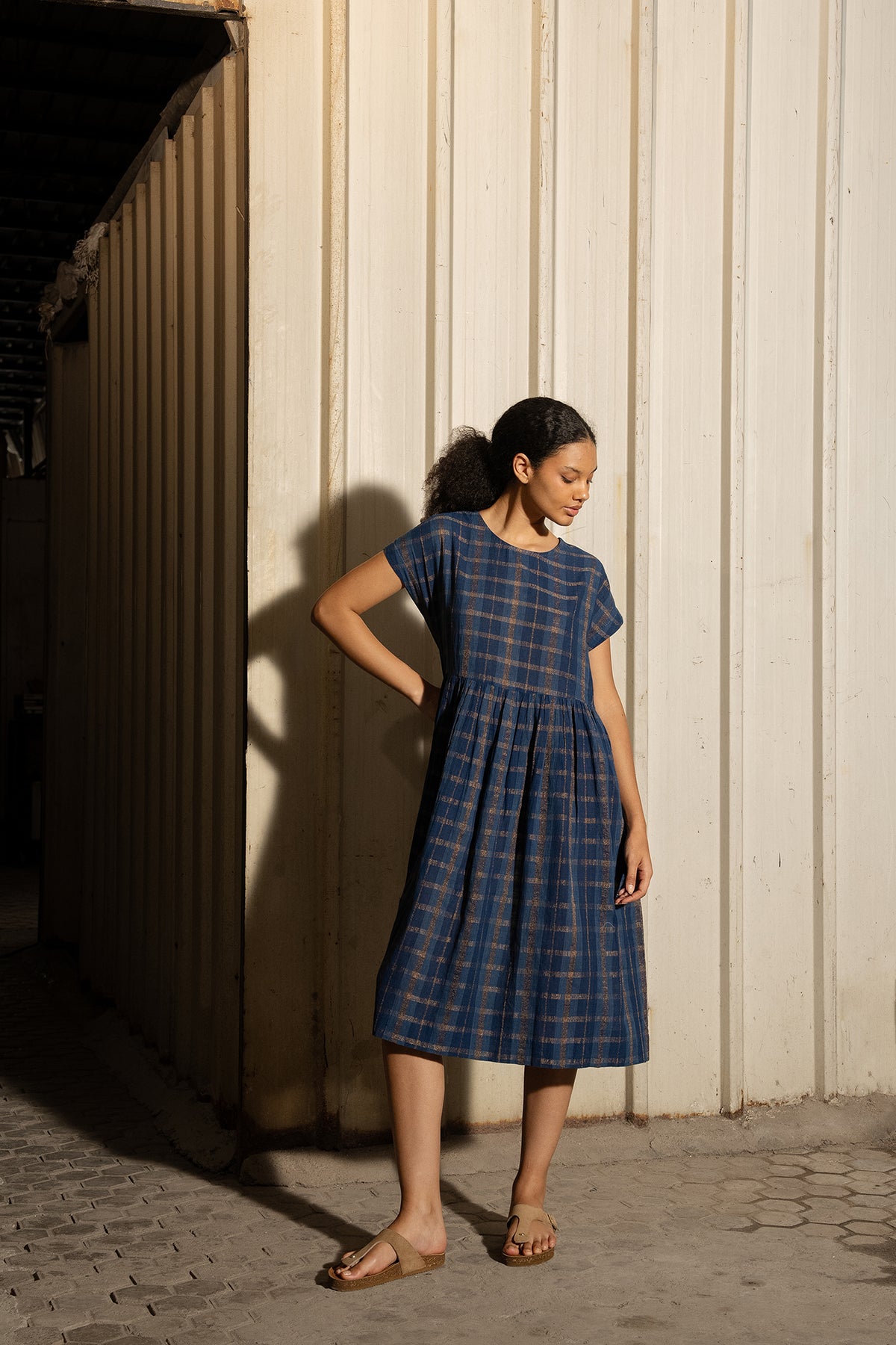 DVE Rayna dress in handloom indigo check cotton with subtle lurex stripe, cap sleeves and gathered skirt with side pockets.