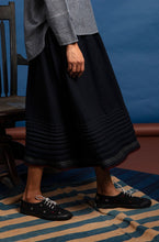 Load image into Gallery viewer, DVE Collection Jiana skirt in soft boiled wool, charcoal black with selvedge detailing, horizontal pleats and side pockets.