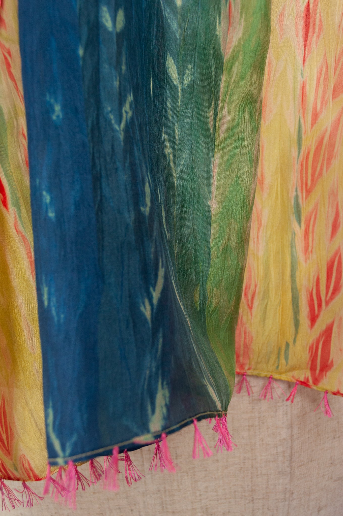 Neeru Kumar 100% silk shibori dyed scarf in lemon, lime, aqua and blue with highlights in vermilion red, tassels and edge stitching in pink.