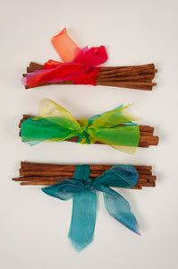 Juniper Hearth cinnamon stick bundles tied with brightly coloured organza ribbons.