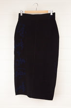 Load image into Gallery viewer, Banana Blue Poly Voly black tube pencil skirt with navy jacquard detail.
