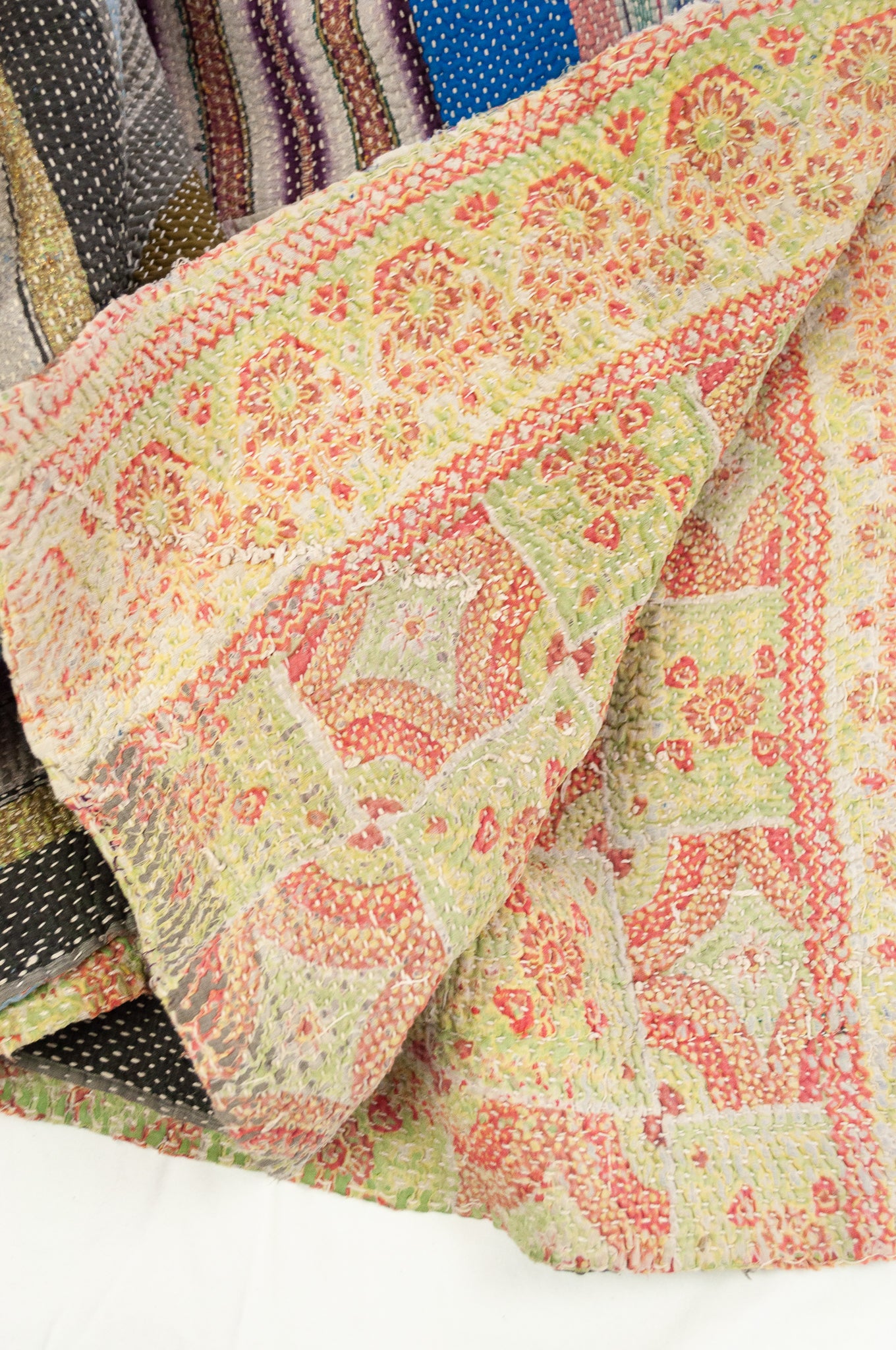 Vintage kantha quilt, heavier weight Mayra, striped patchwork in black and olive green with bright pops of colour, soft vintage green and red floral on reverse.