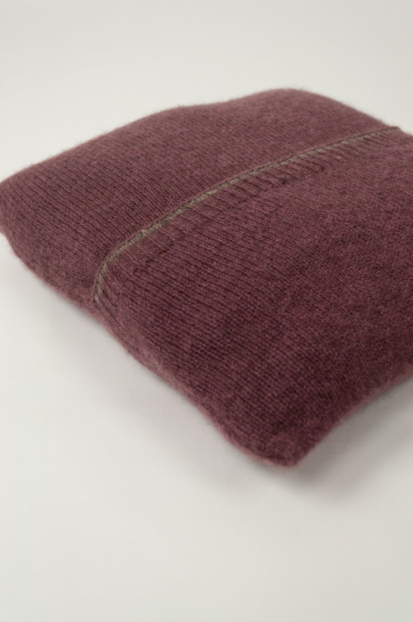 Juniper Hearth baby yak wool poncho in light plum, folded in pouch.