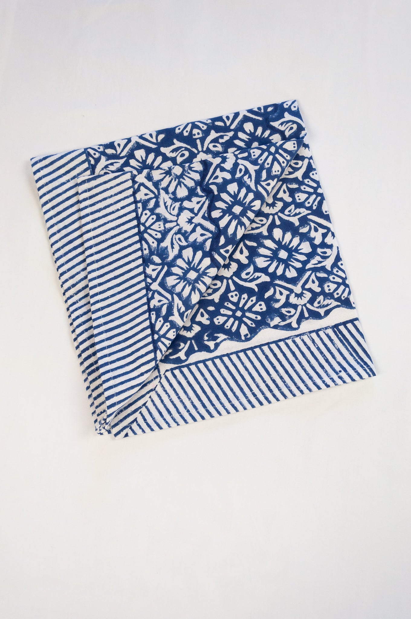 Block print cotton table napkins, Nila indigo blue and white floral print with striped border.